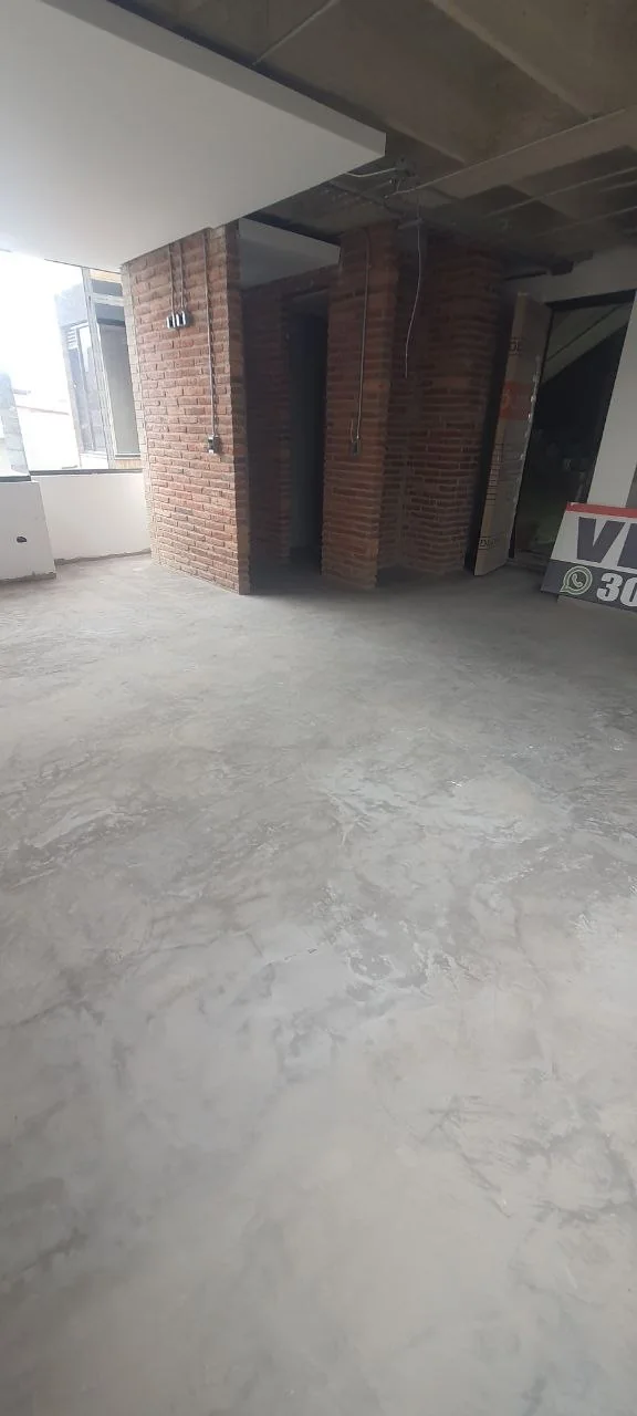 Open-plan interior shell with exposed brick core